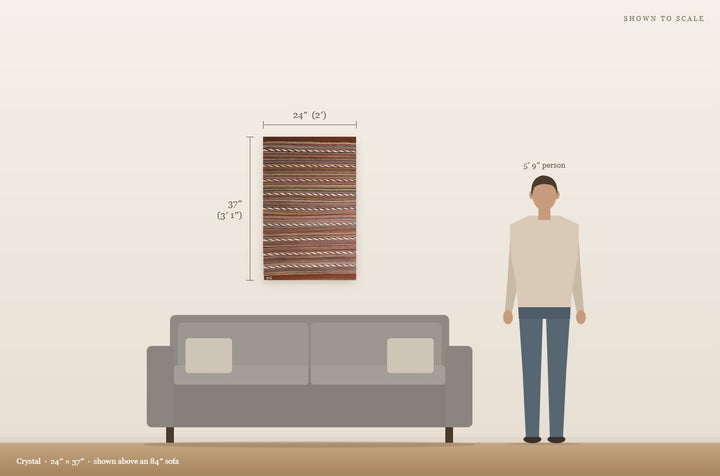 Scale view: Crystal (24″ × 37″) shown on a wall above an 84″ sofa next to a 5′9″ person