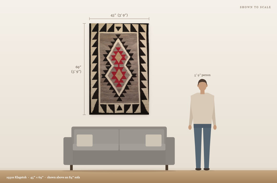 Scale view: 1930s Klagetoh (45″ × 69″) shown on a wall above an 84″ sofa next to a 5′9″ person